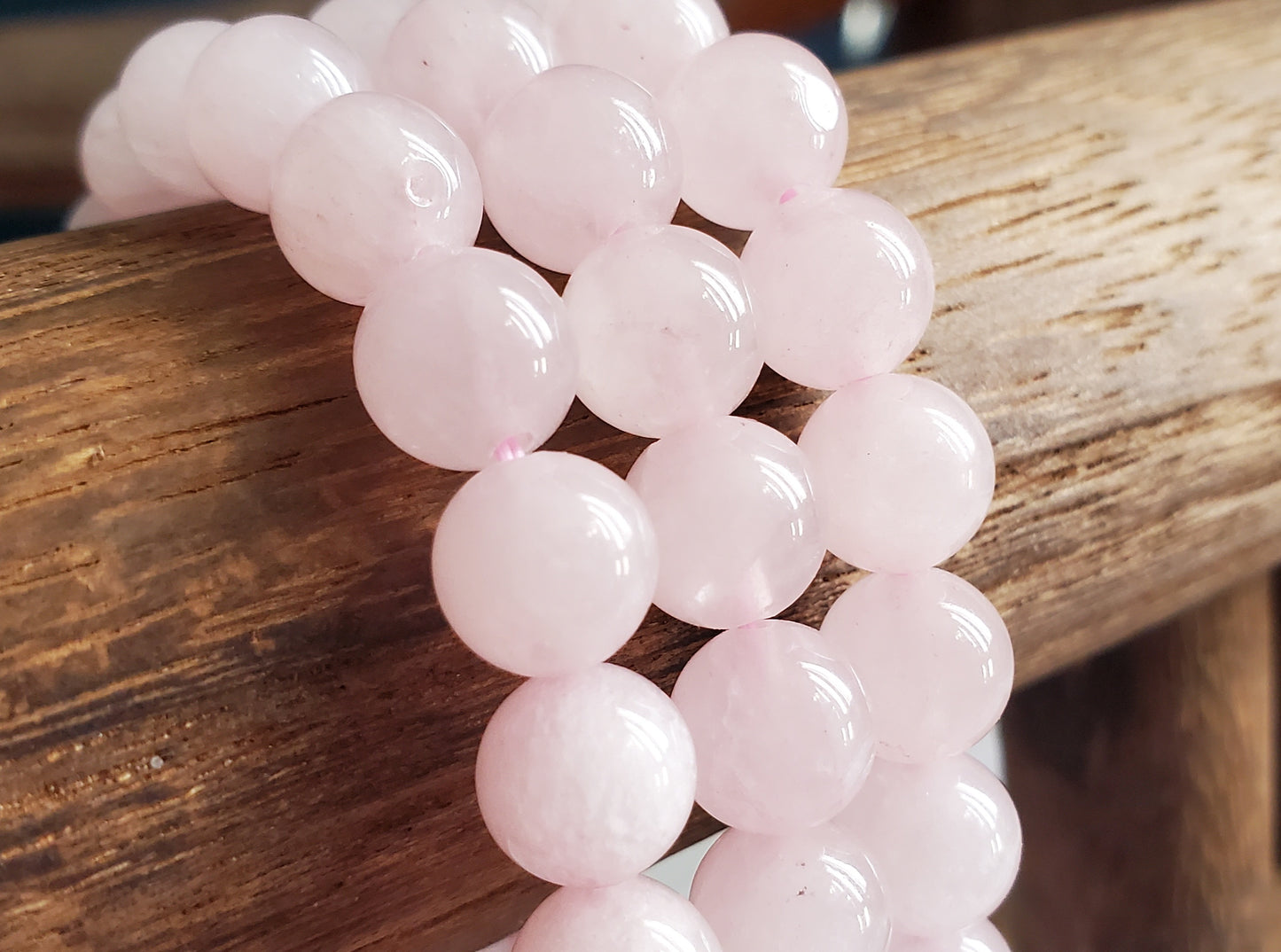 Rose Quartz Bracelet featuring 8mm beads on stretchy string for a 7-inch wrist. They are a soft pink. A blend of elegance and mysticism, radiating the soothing energies of rose quartz. Perfect accessory for love, healing, and positive vibes.